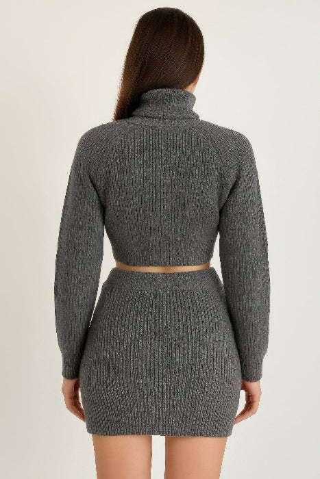 Person wearing a gray knitted two-piece set on a beige background