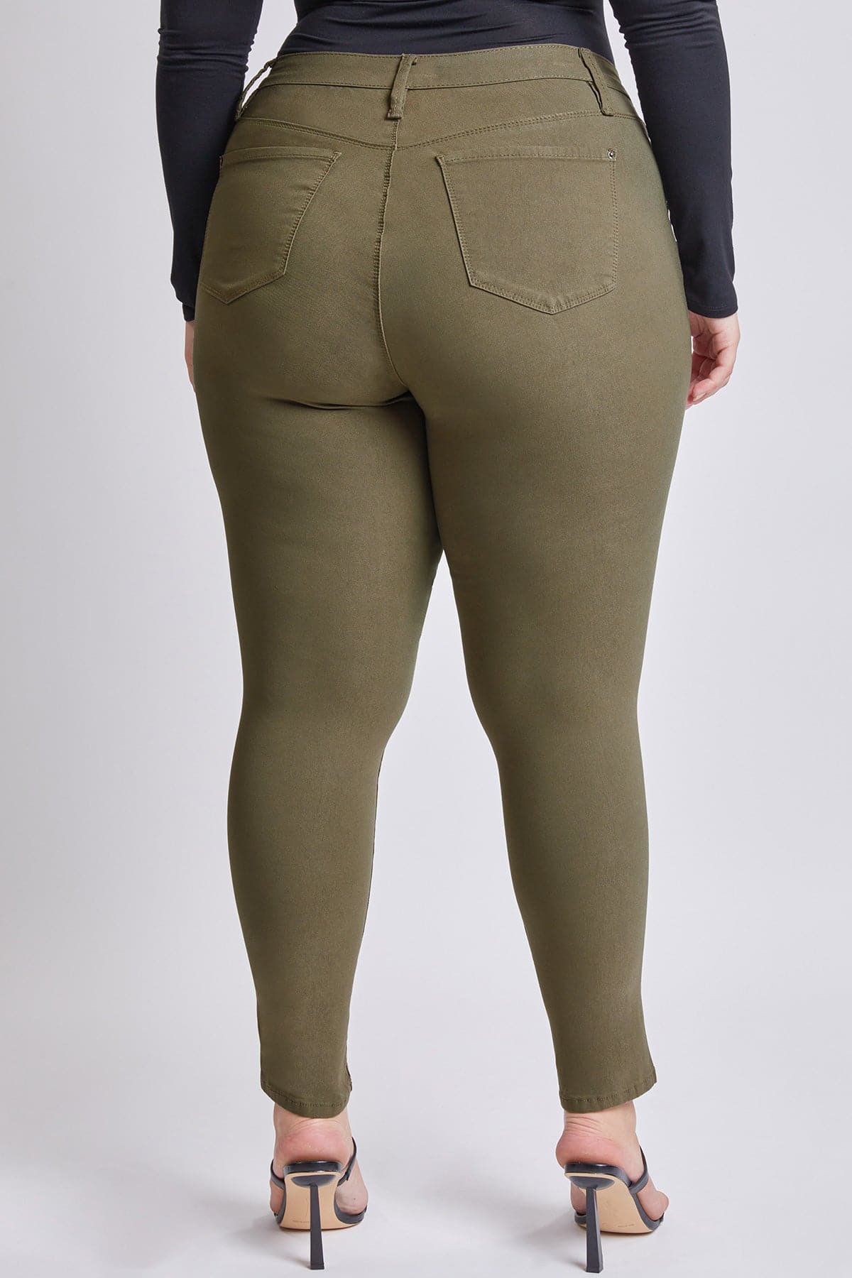 Olive green pants worn by a person on a white background