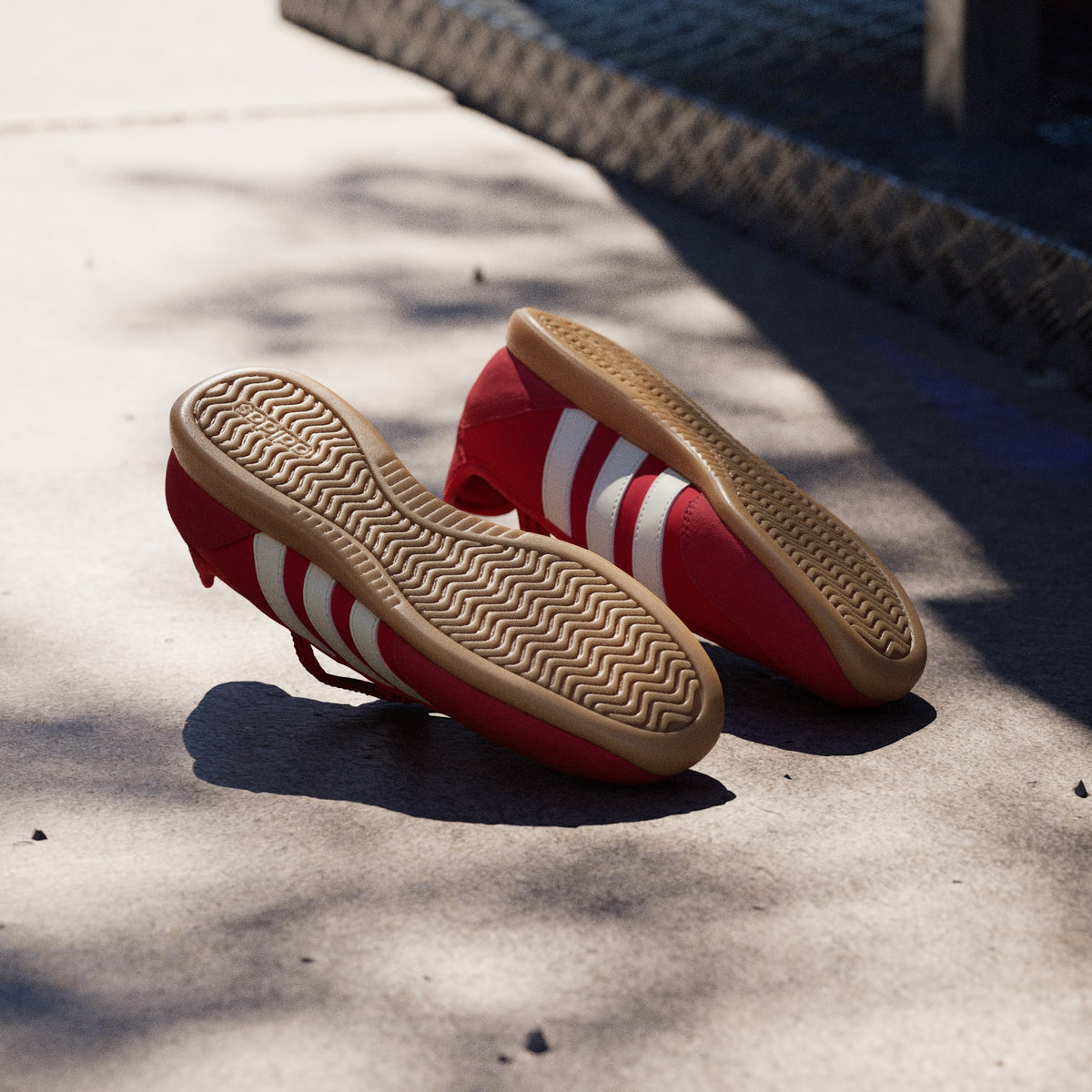 Red Adidas sneaker with white stripes