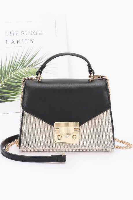 Black and gold handbag with chain detail on a white background