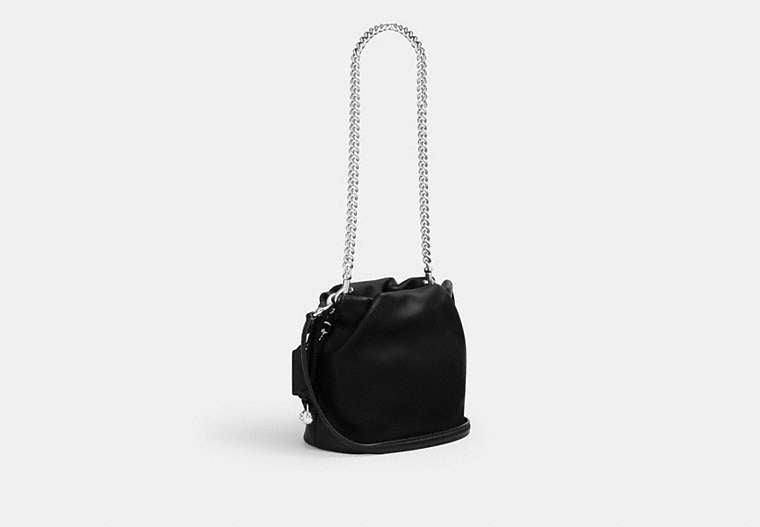 Black Coach Faye Mini handbag with a chain strap on a light gray background