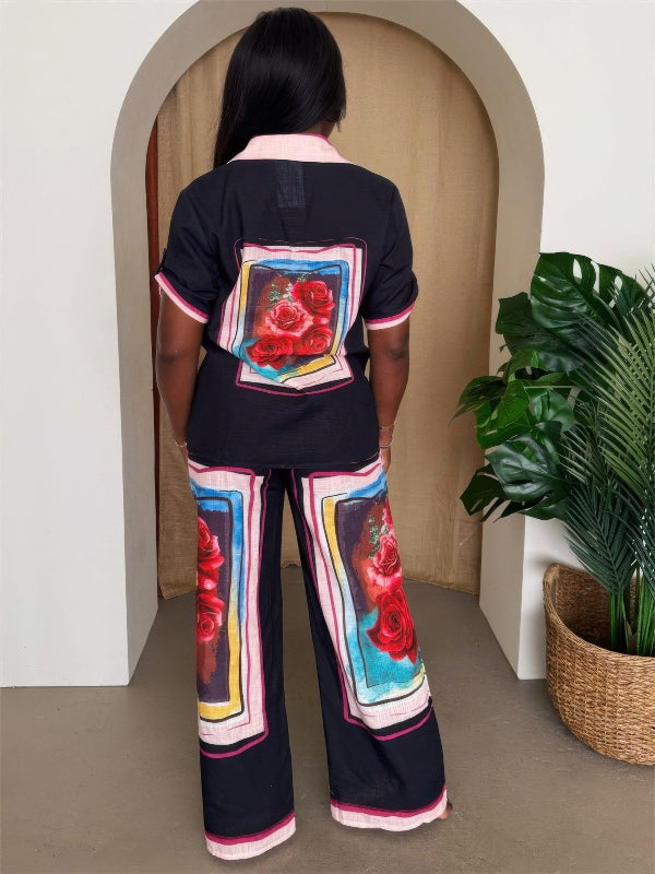 Back view of woman wearing a black outfit with floral designs in a room with a plant.