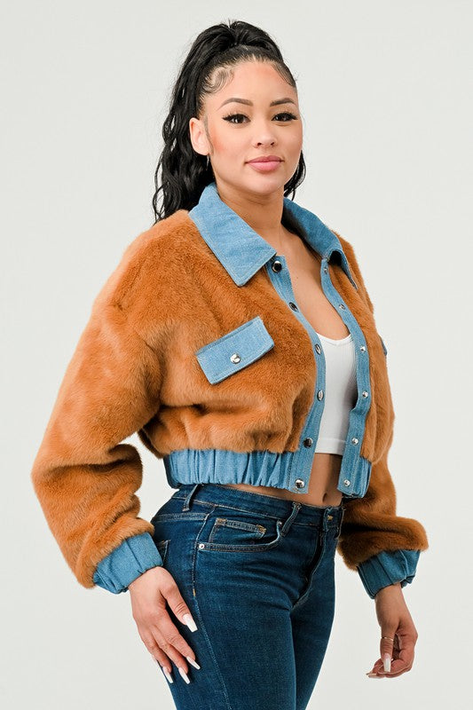 Woman wearing a brown fur jacket with blue denim accents on a white background