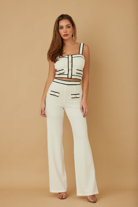 Woman wearing a black and white outfit against a beige background