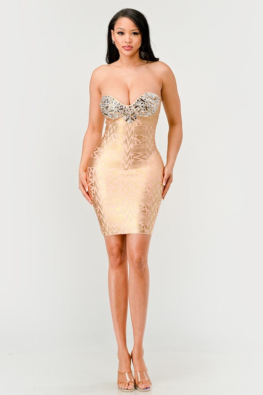 A model wearing a gold, strapless, mini dress with sequins and bead embellishments, featuring a sweetheart neckline.