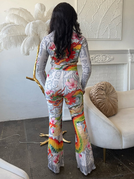 Woman wearing a colorful outfit in a room with a white couch and decorative wall.