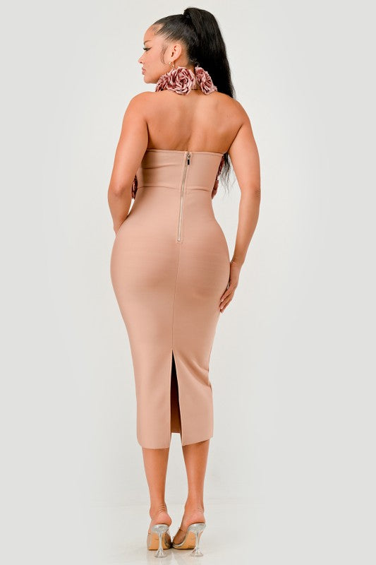 Woman wearing a beige strapless dress with a slit on a white background