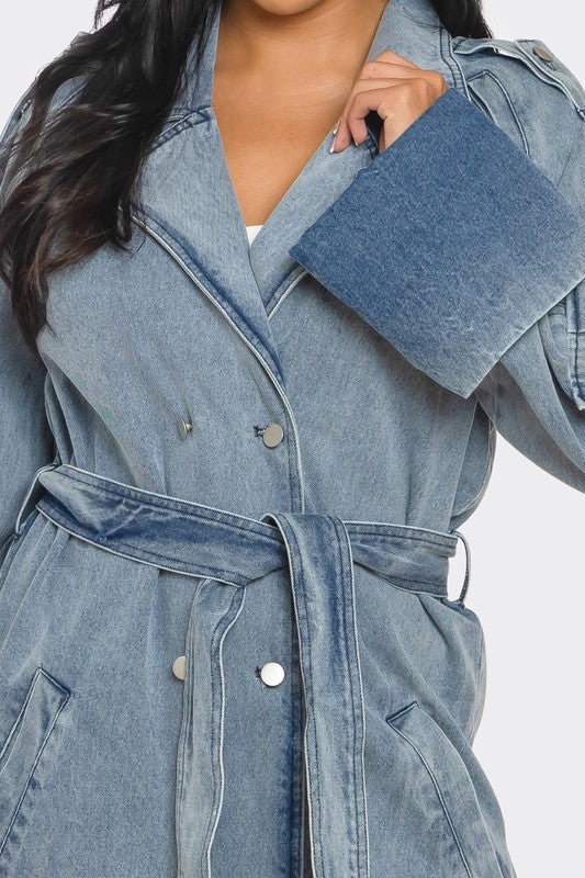Denim trench coat worn by a person on a white background