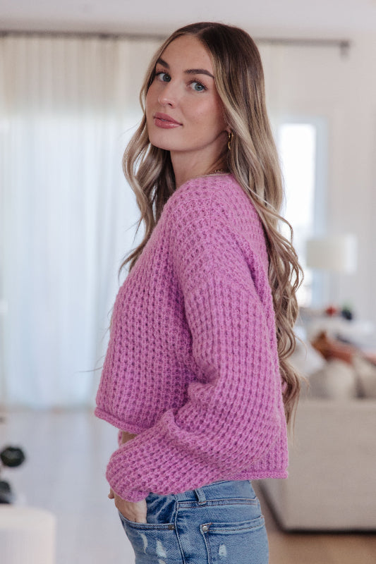 Woman wearing a pink sweater in an indoor setting