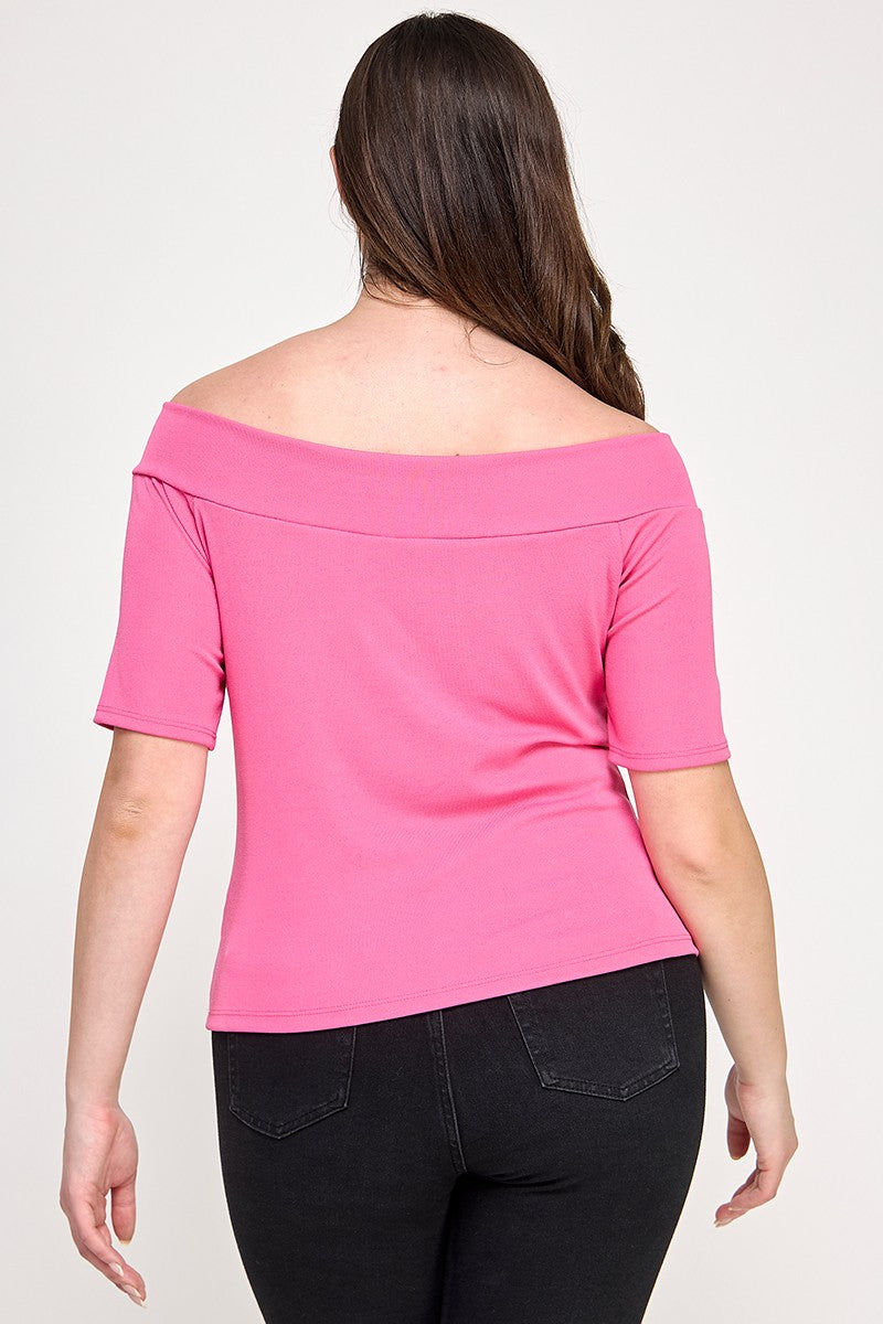 Woman wearing a pink off-shoulder top and black pants on a white background
