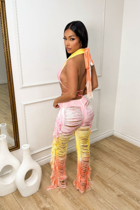 Woman wearing a colorful outfit in a room with white walls and wooden floor.