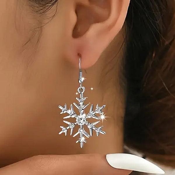 Silver snowflake earring worn by a person