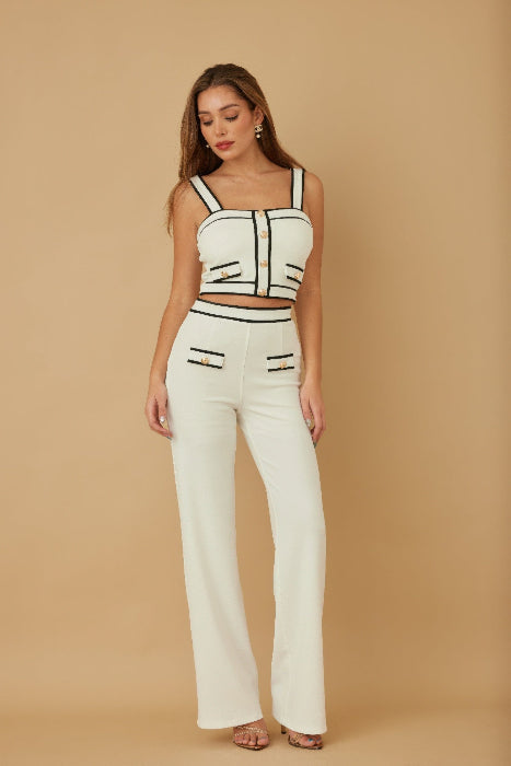 Woman wearing a white outfit with black accents on a beige background