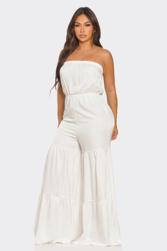 Woman wearing a white strapless jumpsuit on a white background