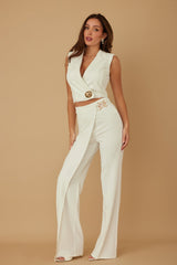 Woman wearing a white outfit with a beige background