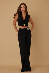 Woman wearing a black outfit with a beige background