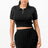Woman wearing a black crop top and pleated skirt on a white background