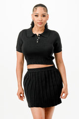 Woman wearing a black crop top and pleated skirt on a white background