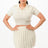 Woman wearing a white outfit with a pleated skirt on a white background