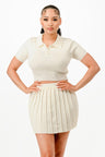 Woman wearing a white outfit with a pleated skirt on a white background