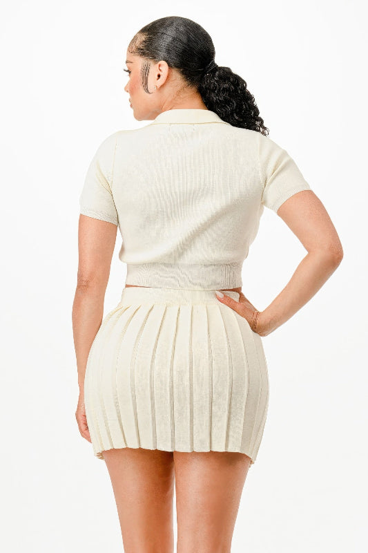 back view of Woman wearing a white pleated dress on a plain background