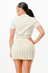 back view of Woman wearing a white pleated dress on a plain background