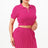 Woman wearing a bright pink polo shirt and pleated skirt on a white background