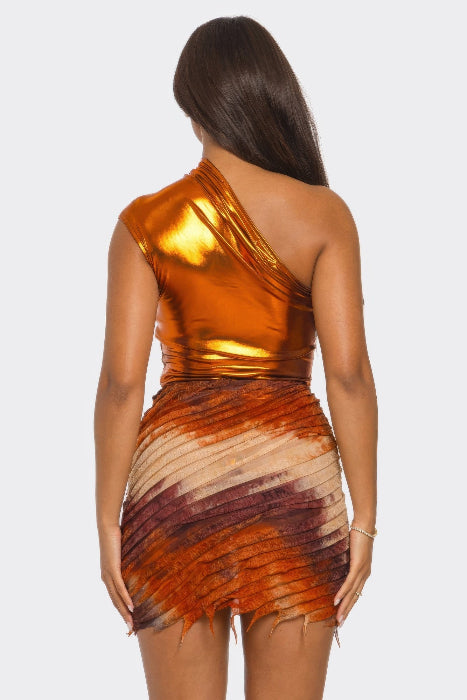 Woman wearing a one-shoulder metallic skirt set with a gradient design on a white background