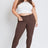 Woman wearing a white crop top and brown pants on a white background