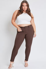 Woman wearing a white crop top and brown pants on a white background
