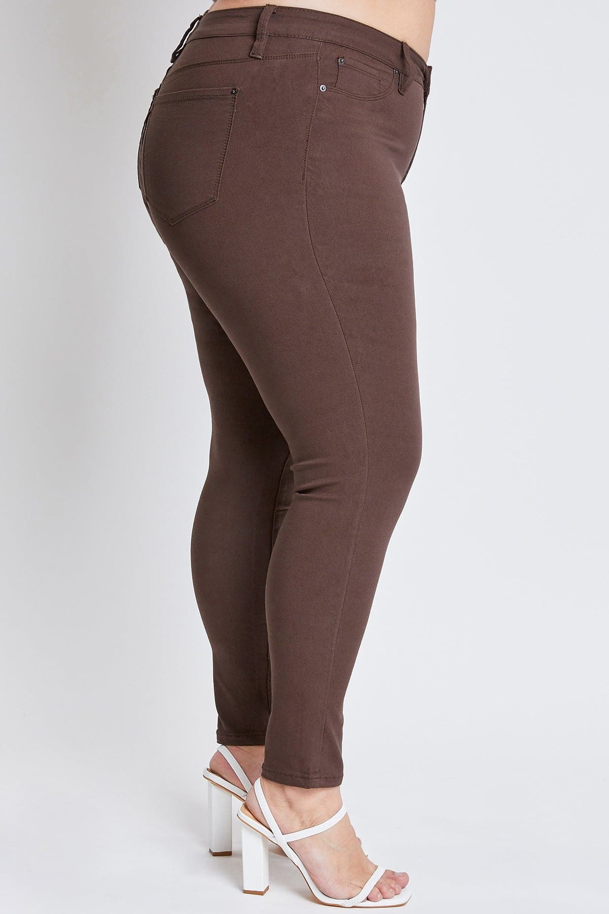 Brown pants worn by a person on a white background