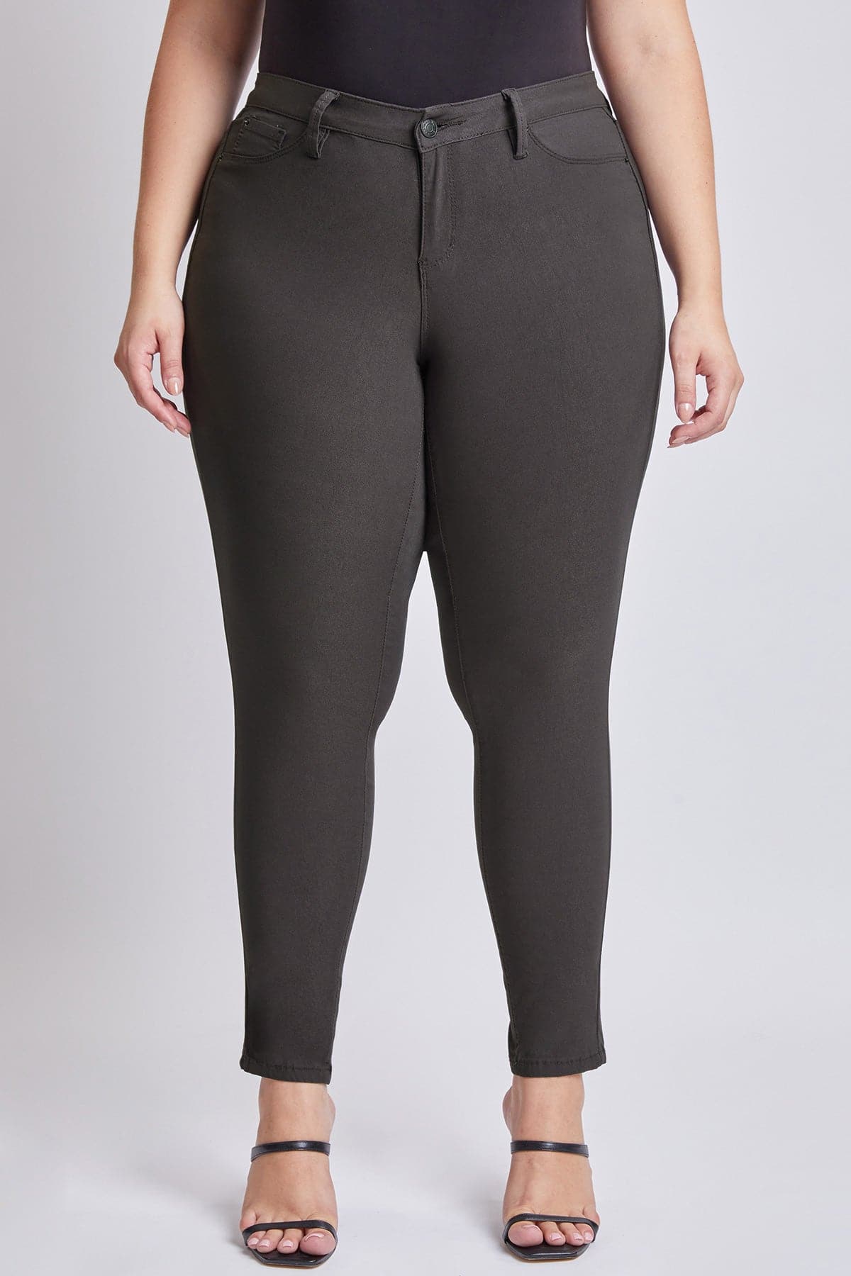 Dark gray pants worn by a person on a white background