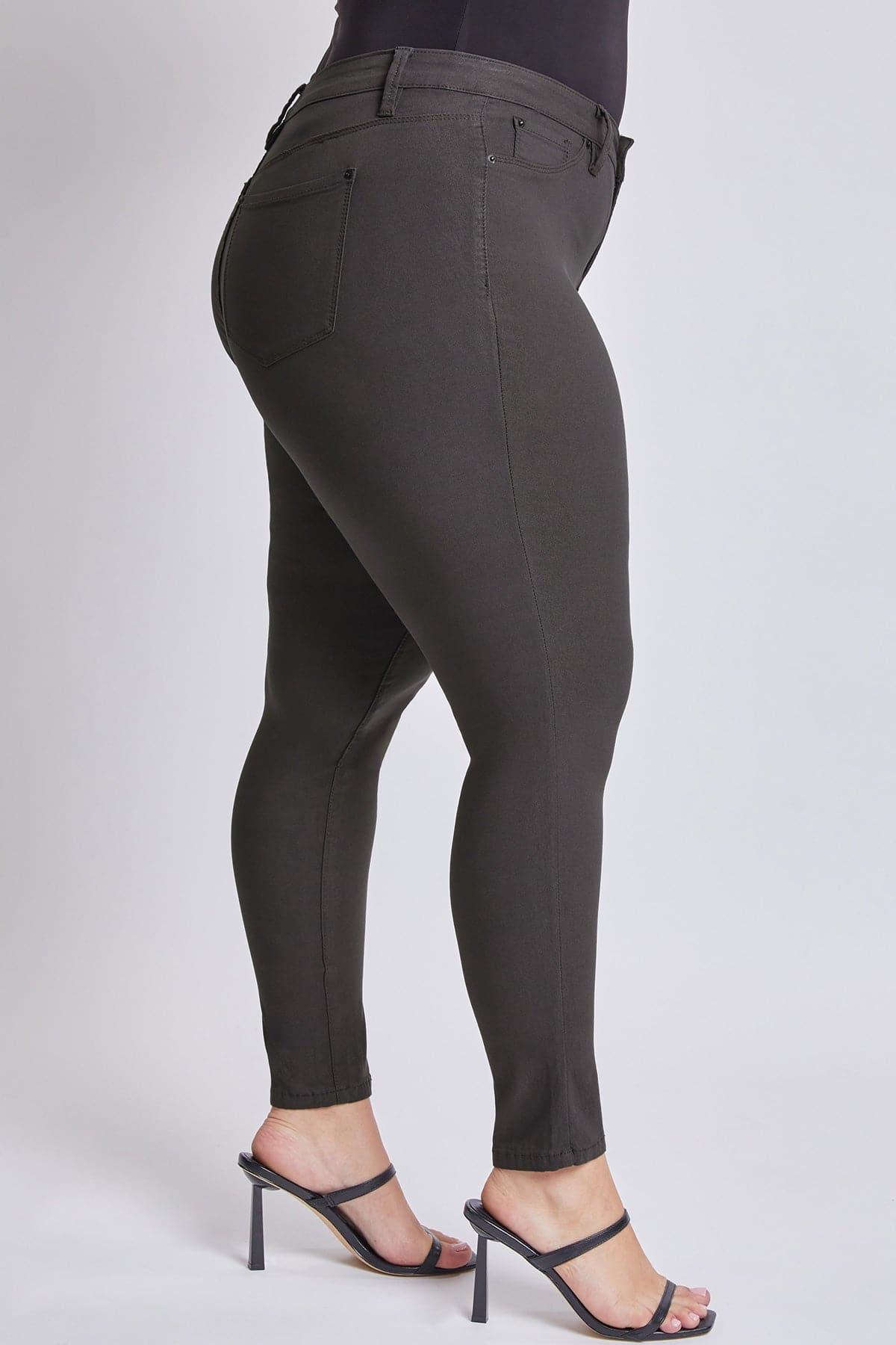 Person wearing black leggings on a plain background
