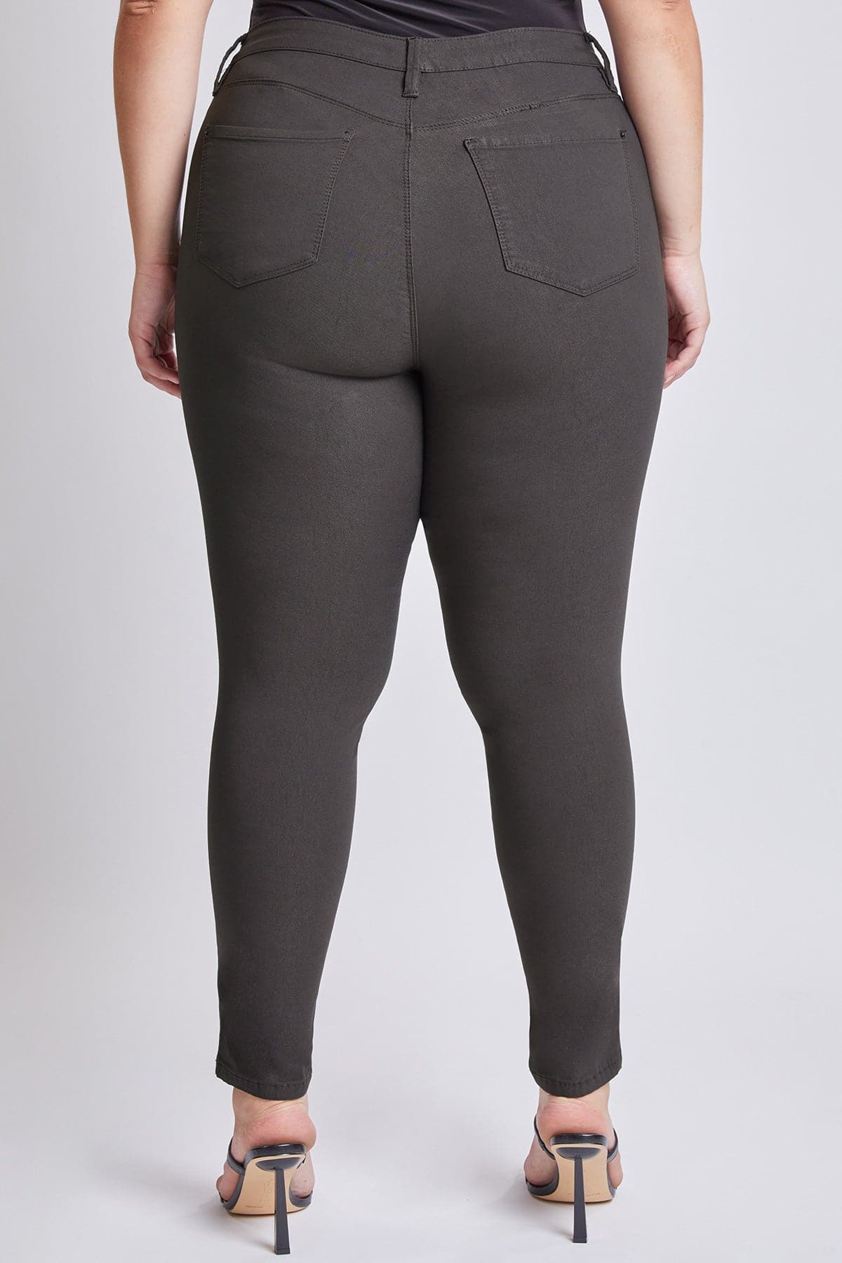 Dark gray pants worn by a person on a white background