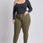 Woman wearing a black long-sleeve top and olive green pants on a white background