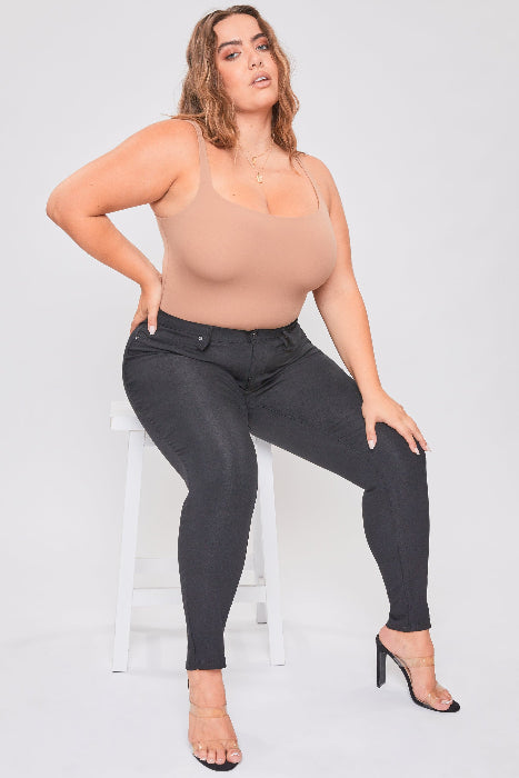 Woman wearing a beige top and black pants on a white background