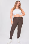 Woman wearing brown pants and a white top on a white background