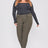 Woman wearing a black long-sleeve top and green pants on a white background