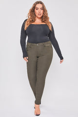 Woman wearing a black long-sleeve top and green pants on a white background