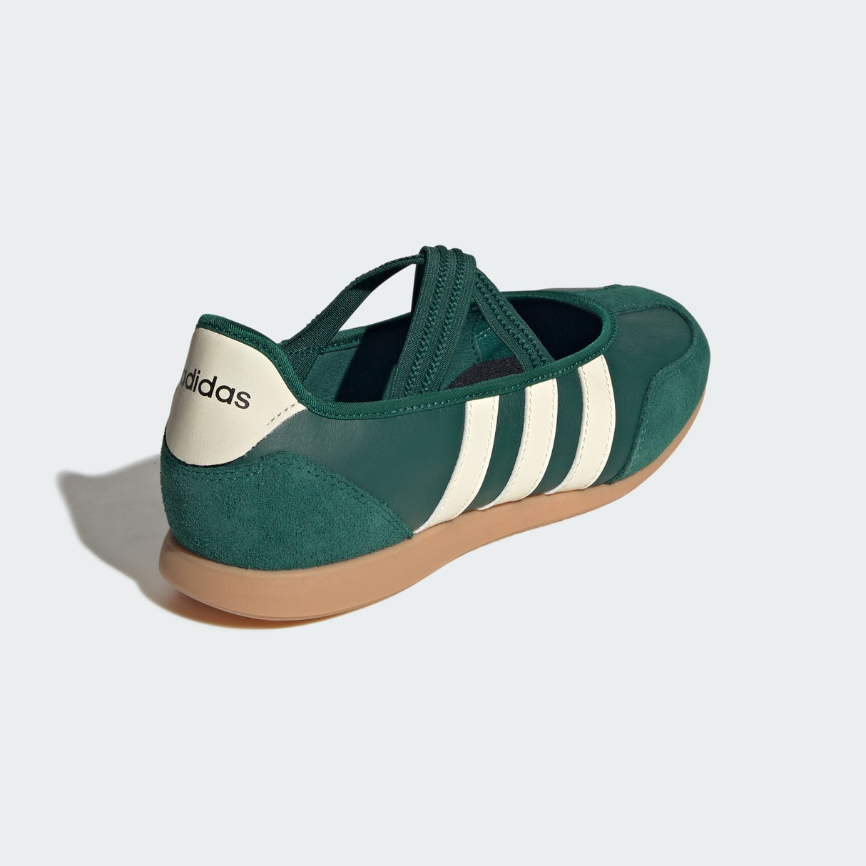 Green Adidas mary jane shoe with white stripes on a light gray background