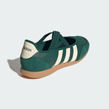Green Adidas mary jane shoe with white stripes on a light gray background