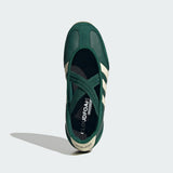 Green Adidas sneaker with white stripes on a light gray background