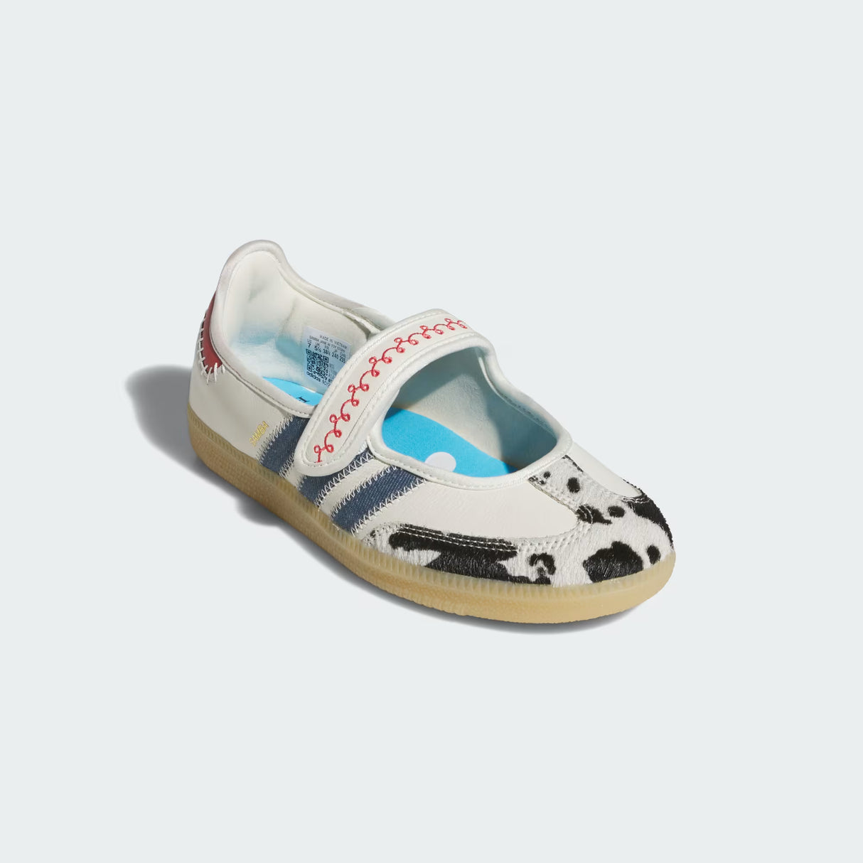 White Adidas Pixar Toy Story Samba Jane Shoes with cow print sole on a light gray background