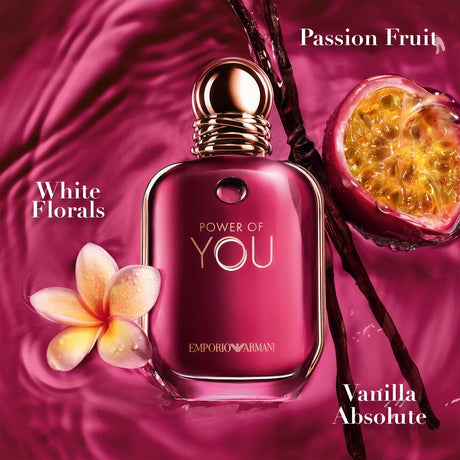 Pink Emporio Armani perfume bottle with floral and fruit elements on a pink background