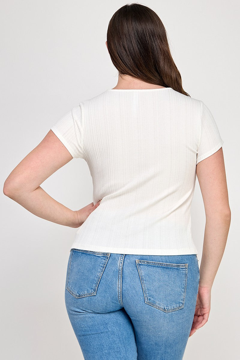 Woman wearing a white t-shirt and blue jeans on a plain background