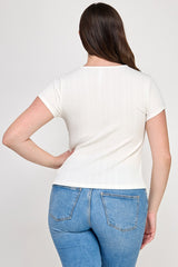 Woman wearing a white t-shirt and blue jeans on a plain background