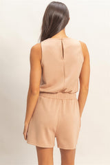 Woman wearing a beige Drawstring Waist Sleeveless Romper on a plain background