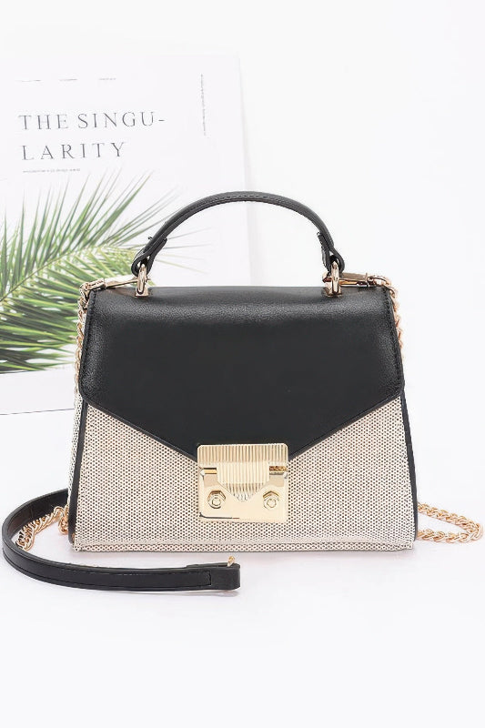 Black and gold handbag with chain detail on a white background