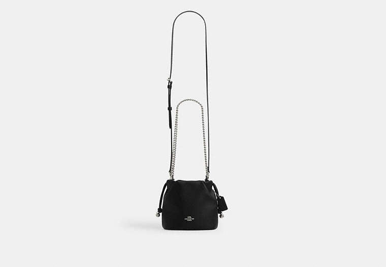 Black Coach Faye Mini handbag with a chain strap on a light gray background
