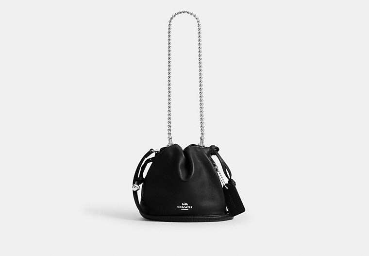 Black Coach Faye Mini handbag with chain strap on a white background